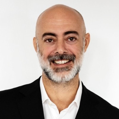 Smiling man with bald head and salt-and-pepper beard.