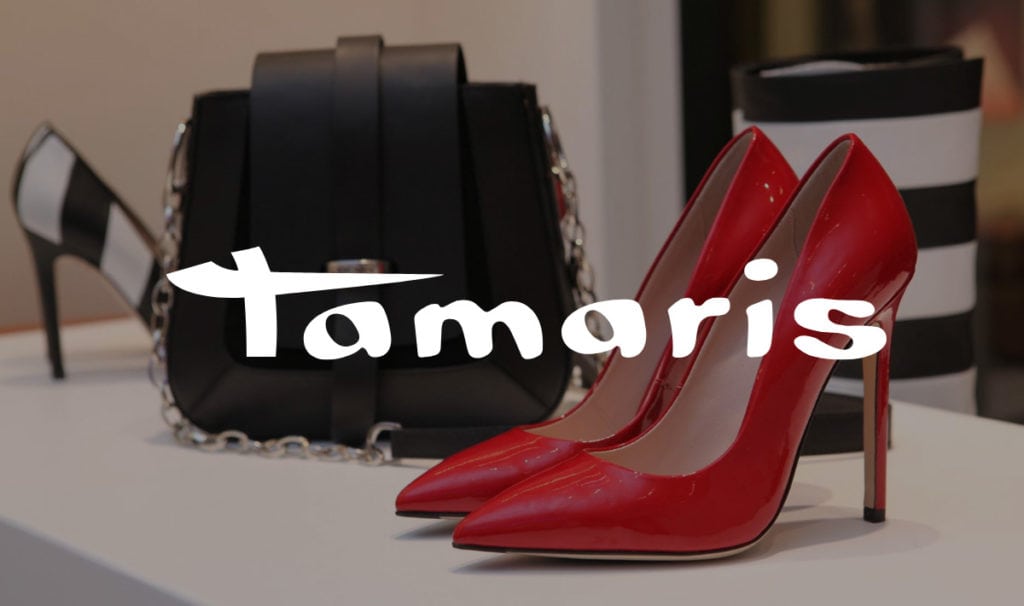 Red high-heeled pumps and black handbag with Tamaris logo.