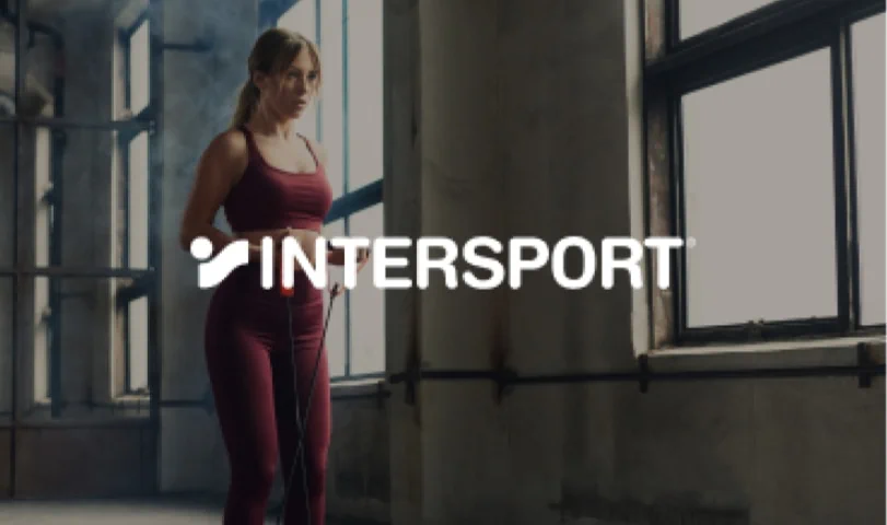 Woman in maroon sportswear holding a jump rope, INTERSPORT logo.