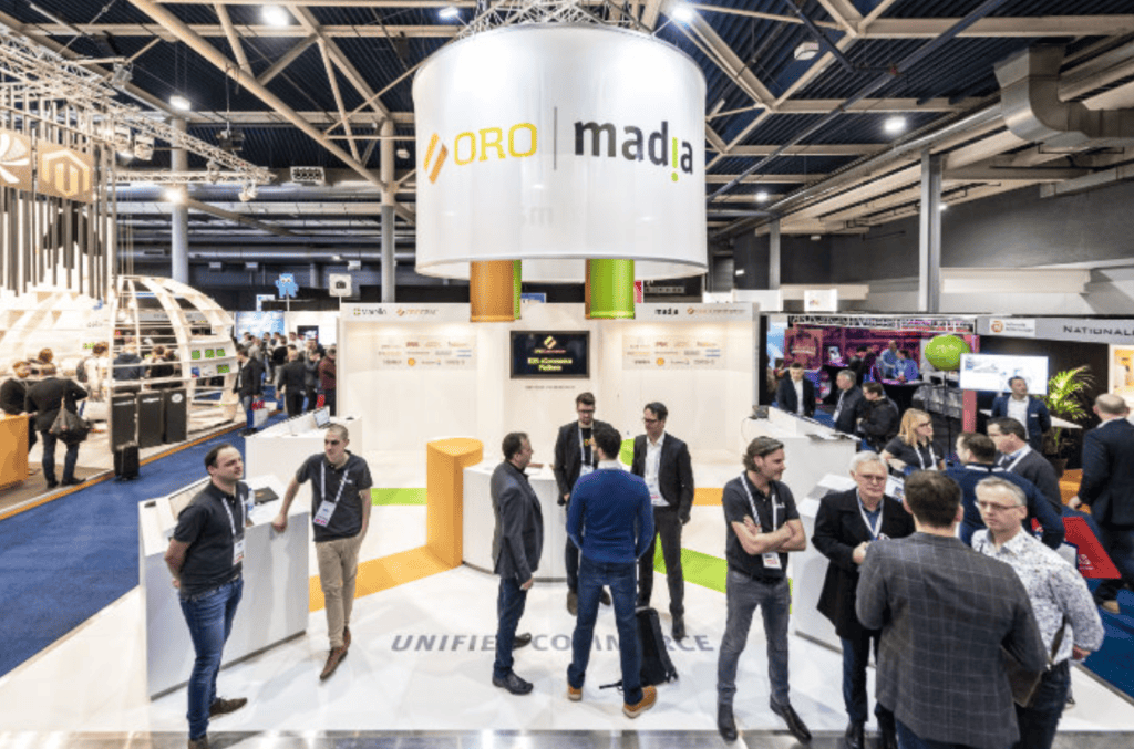 People networking at the ORO madia booth at a tradeshow.