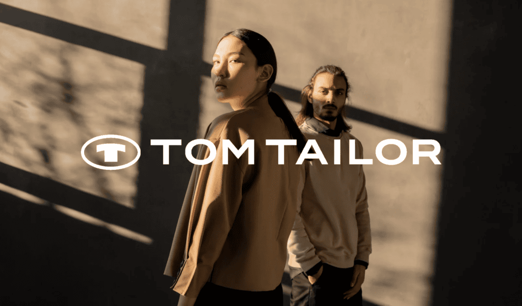 Tom Tailor brand advertisement featuring two models in sepia.