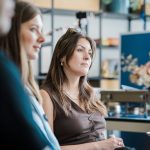 A woman looking thoughtfully during a meeting in an office.