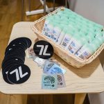 Sunscreen tubes and 7L stickers on a wooden table.
