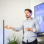 A man giving a presentation in front of a screen.