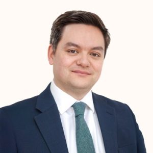Professional headshot of a man in a suit and tie.