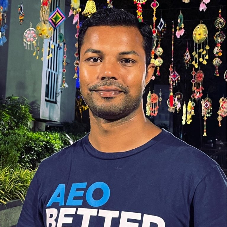 Smiling man in a navy AEO BETTER t-shirt.