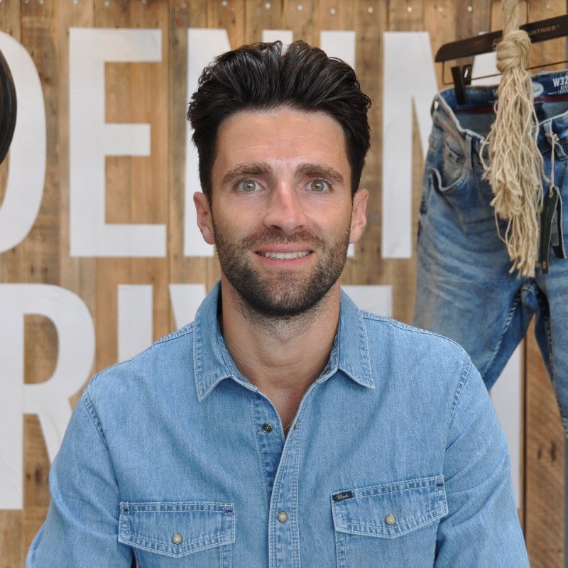 Portrait of a man wearing a blue denim shirt.