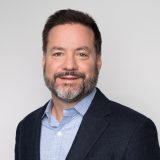 Portrait of a man with a beard wearing a blazer.