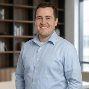 Smiling man in a blue shirt in an office.