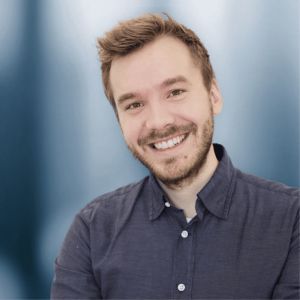Smiling young man with a beard in a blue shirt